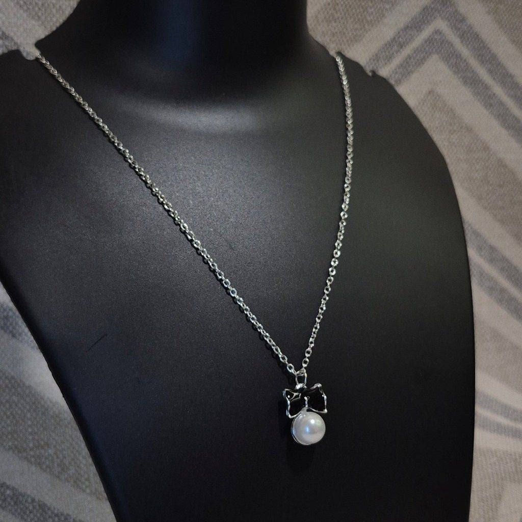 Silver chain bow and pearl pendant